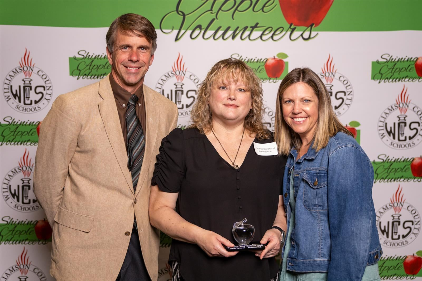  Three people getting their picture taken for an award